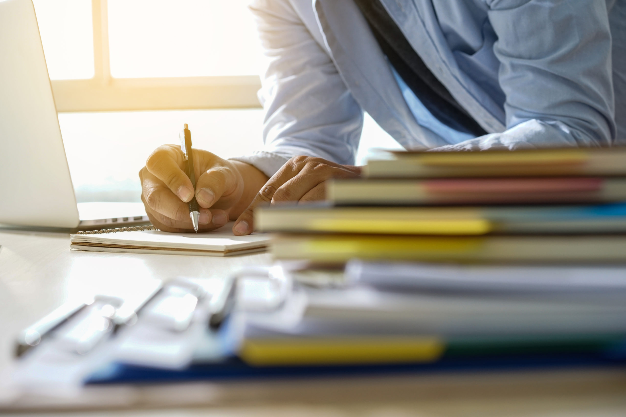 Professional writing detailed franchise operations manual with organized binders and checklists for business documentation